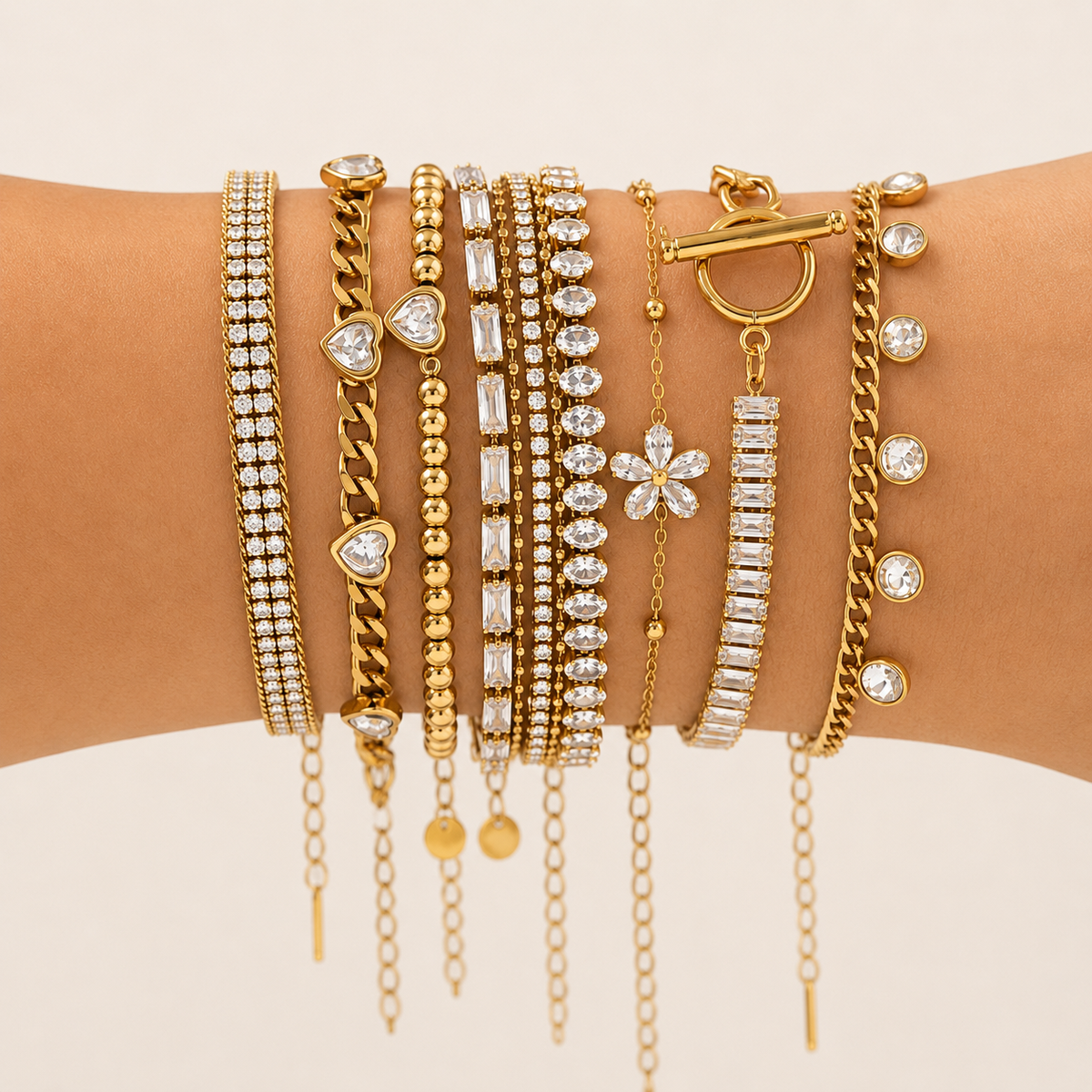 Gold plated bracelets stacked on wrist showing sparkling crystal and chain designs
